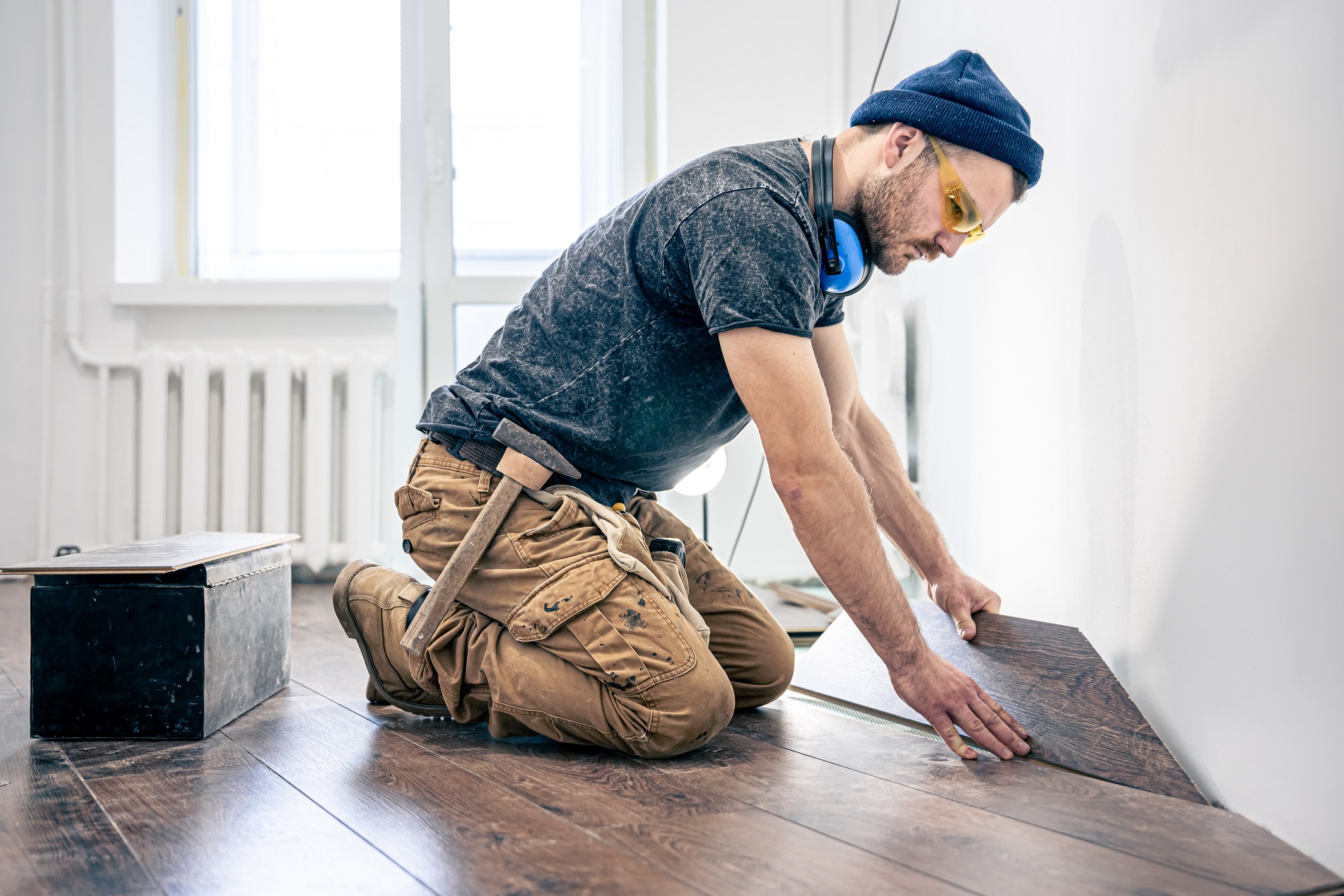 a male worker puts laminate flooring on the floor 2022 01 11 04 18 58 utc