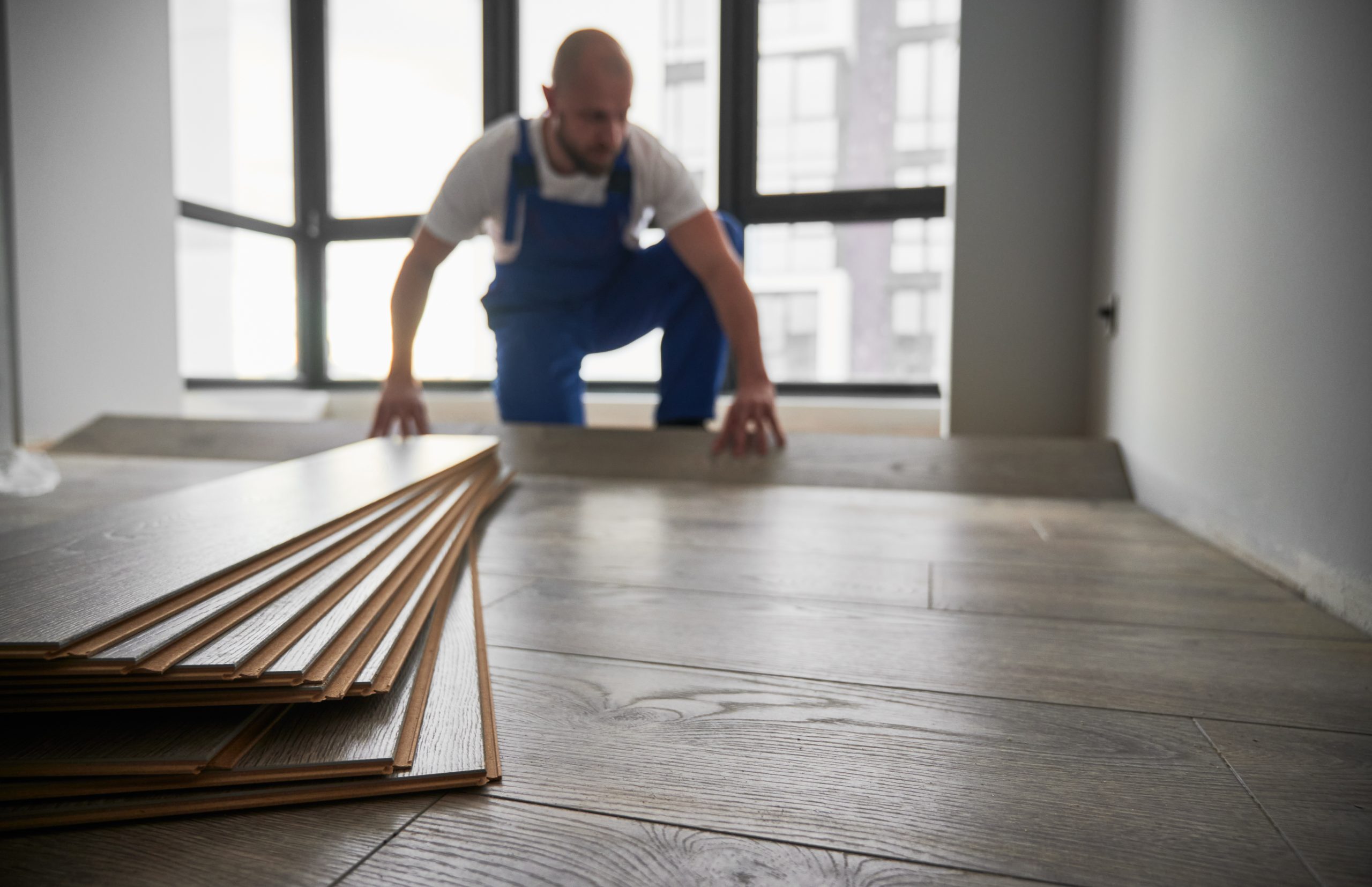 laminate planks and male flooring installer on bac 2023 04 03 19 25 14 utc scaled